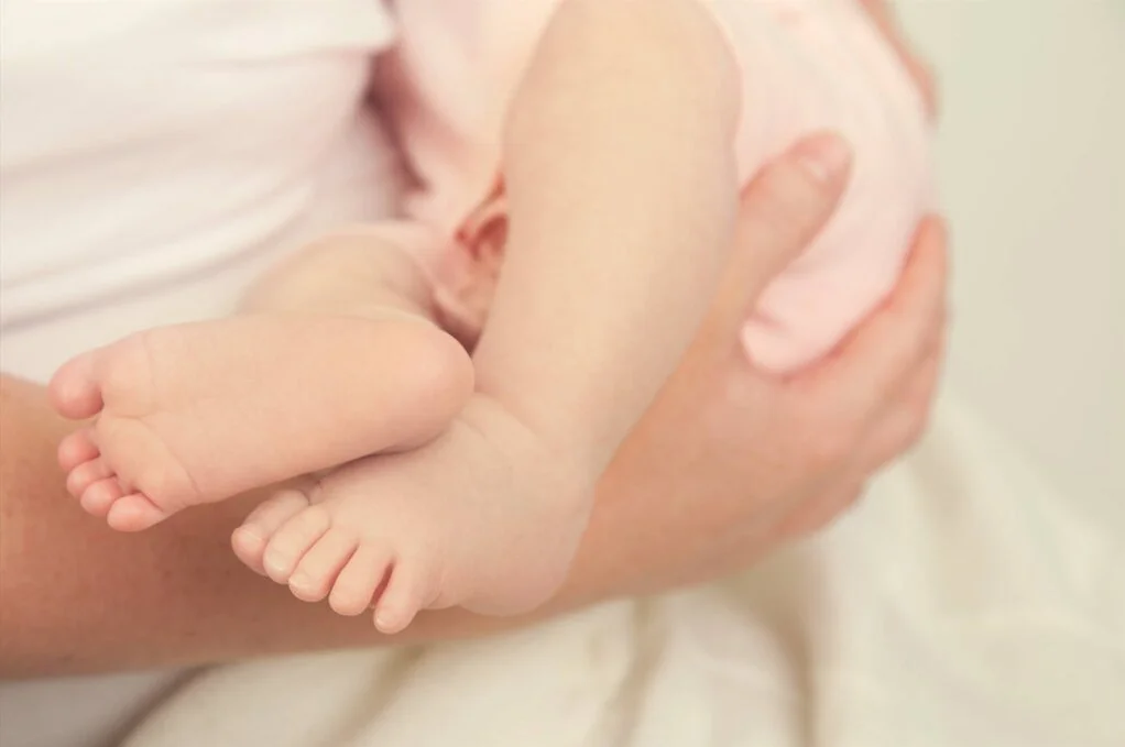Eine Mutter hält Ihr Baby im Arm.
