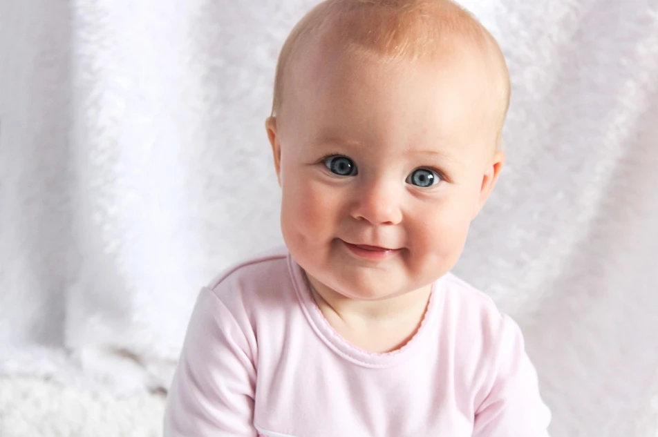 Ein niedliches Baby schaut vergnügt